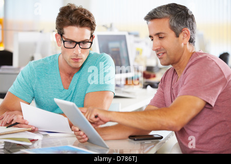 Two Men Using Tablet Computer In Creative Office Stock Photo