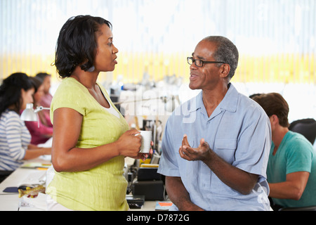 Workers Chatting In Busy Creative Office Stock Photo