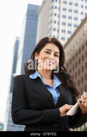 Businesswoman Working On Tablet Computer Outside Office Stock Photo