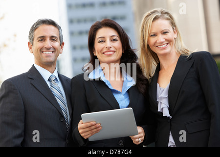 Businessman And Businesswomen Using Digital Tablet Outside Stock Photo