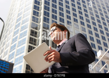Businessman Working On Tablet Computer Outside Office Stock Photo