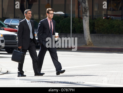 Two Businessman Chatting Whilst Crossing Street Stock Photo
