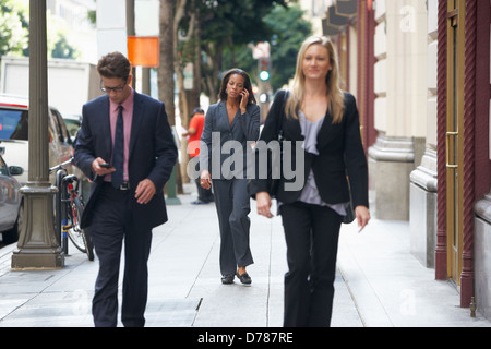 Group Of Businesspeople Walking Along Street Stock Photo