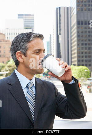 Businessman Drinking Takeaway Coffee Outside Office Stock Photo