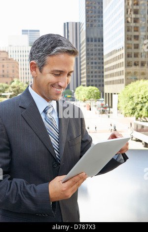 Businessman Working On Tablet Computer Outside Office Stock Photo