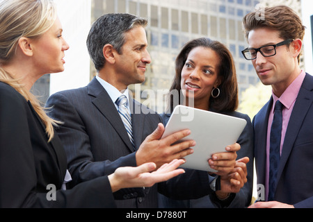 Businessmen And Businesswomen Using Digital Tablet Outside Stock Photo