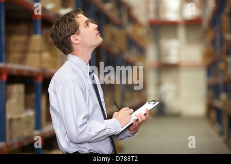 Manager In Warehouse With Clipboard Stock Photo