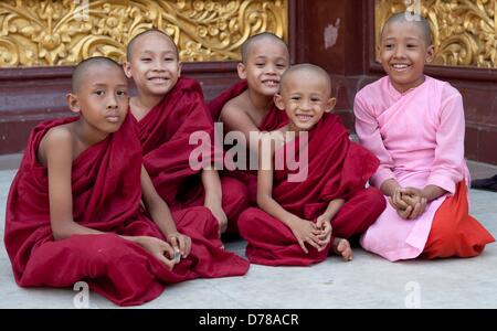 Myanmar Young Buddhist monks and a Buddhist nun are sitting together at the Shwedagon Pagoda in Rangun, Myanmar, on 30.03.2013. Photo: Sebastian Kahnert Stock Photo