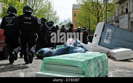 Berlin, Germany. 1st May 2013. Police officers run past a portable toilet that was overturned by left-wing demonstrators in the quarter Schöneweide in Berlin, Germany, 01 May 2013. Photo: OLE SPATA/dpa/Alamy Live News Stock Photo