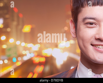 Close-up of smiling young business man, city lights background Stock Photo