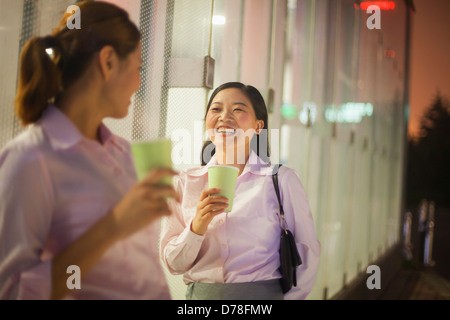 Young businesswomen smiling and drinking coffee outdoor Stock Photo