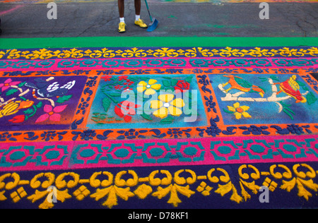 A person sweeps the road by a sawdust carpet during Semana Santa in La Antigua Guatemala Stock Photo