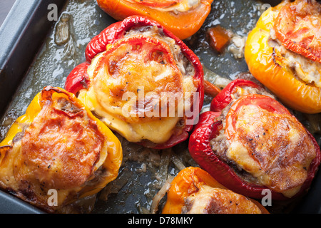 Baked bell peppers stuffed with chopped meat on black baking pan Stock Photo