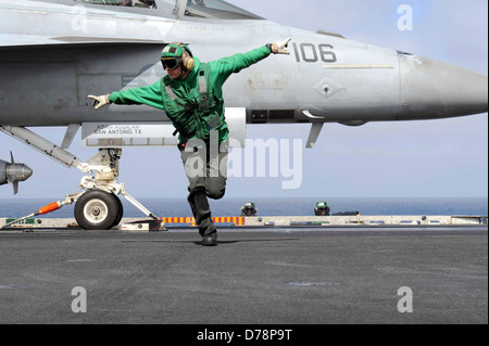 US Navy Aviation Boatswain's Mate 3rd Class Justin Bryan signals launch for a F-A-18F Super Hornet on the flight deck aboard the aircraft carrier USS John C. Stennis April 29, 2013 in the Pacific Ocean. Stock Photo