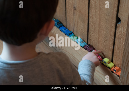 Boy playing with little car toys Stock Photo