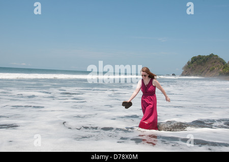 Woman running on Hermosa beach in the Ocean, Puntarenas, Costa Rica Stock Photo