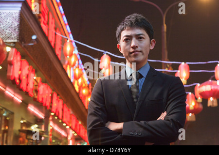 Businessman standing on the street, red lanterns on the background Stock Photo