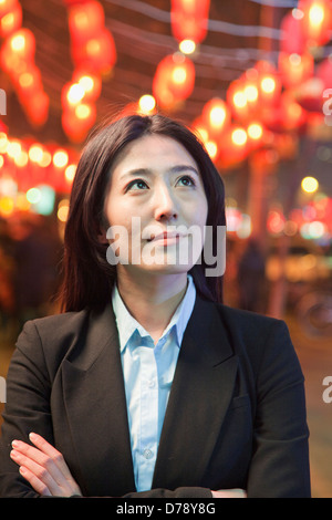 Businesswoman standing on the street, red lanterns on the background Stock Photo