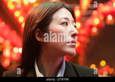 Businesswoman standing on the street, red lanterns on the background Stock Photo