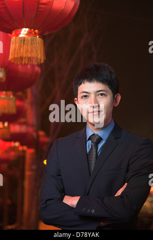 Businessman standing on the street, red lanterns on the background Stock Photo