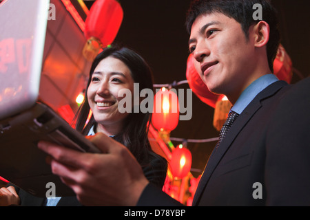 Coworkers working at night, City street, red lanterns on the background Stock Photo