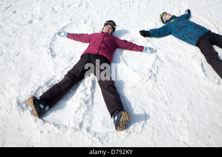 Man and Woman Lying on the Snow Making Snow Angel Stock Photo