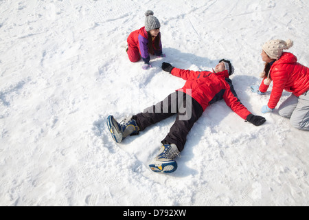 Family Playing in the Snow, Father Making Snow Angel Stock Photo