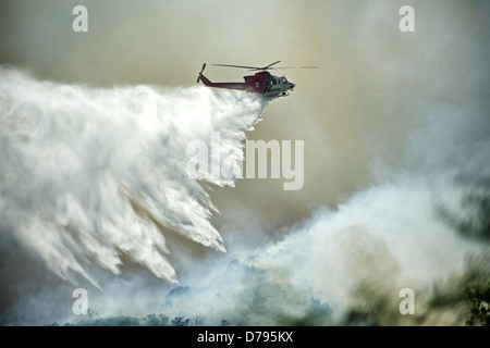 Firefighting helicopter drops water on a southern California wildfire. Stock Photo