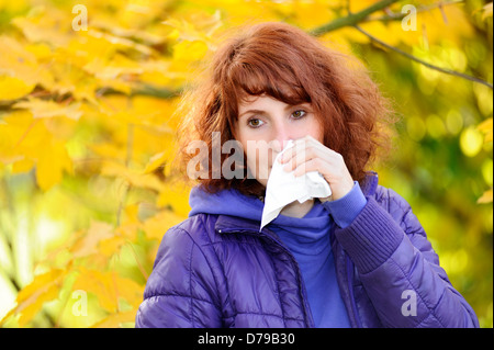 Woman with handkerchief in autumnal surroundings, cold , Frau mit Taschentuch in herbstlicher Umgebung, Erkältung Stock Photo