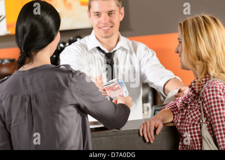 Female customers paying by cash euro in bar to bartender Stock Photo