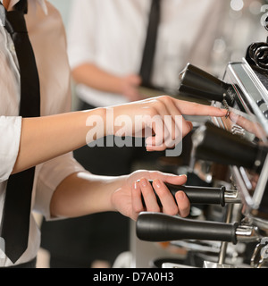 Waitress operating espresso machine coffee in house Stock Photo