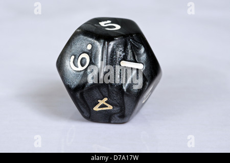 Platonic dodecahedron 12 sided die against a grey background. Stock Photo