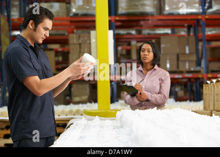 Factory Worker And Manager Checking Goods On Production Line Stock Photo