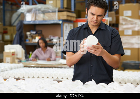 Factory Worker Checking Goods On Production Line Stock Photo