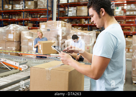 Worker Using Tablet Computer In Distribution Warehouse Stock Photo