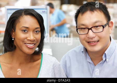 Two Workers At Computer Terminal In Distribution Warehouse Stock Photo