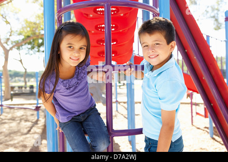 Boy And Girl On Climbing Frame In Park Stock Photo