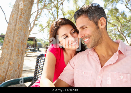 Romantic Couple Sitting On Park Bench Together