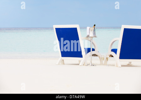 Bottle Of Champagne Between Chairs On Beautiful Beach Stock Photo