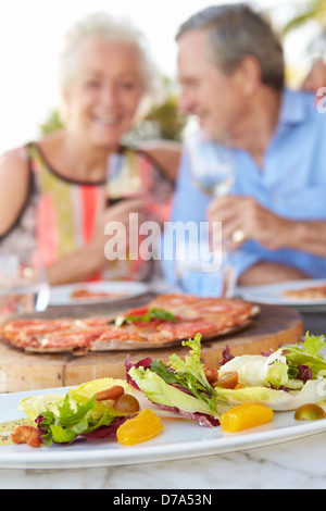 Senior Couple Enjoying Meal In Outdoor Restaurant Stock Photo