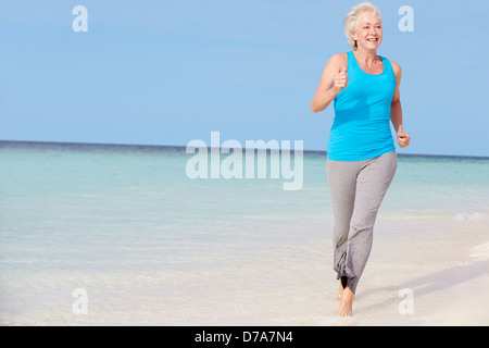 Senior Woman Running On Beautiful Beach Stock Photo