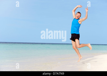 Senior Man Jumping On Beautiful Beach Stock Photo