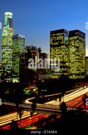 The skyline of downtown Los Angeles, California, USA, glows at dusk with the lights of office buildings and freeway traffic. Stock Photo