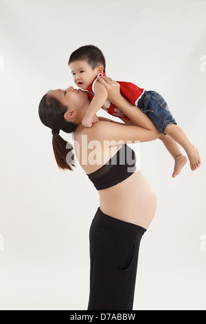 Mother carrying her son up Stock Photo