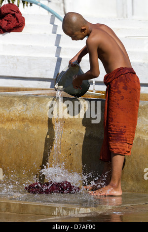 A monk washes his robes in Shwe Yaunghwe Kyaung Monastery near to Lake Inle, Myanmar Stock Photo