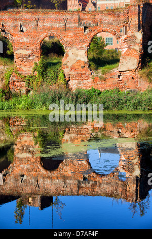 Ruins of an old building with reflections on Motlawa river waters, destroyed during World War II, city of Gdansk, Poland. Stock Photo