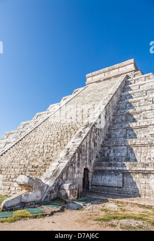 Kukulkan Pyramid at Chichen Itza Yucatan Mexico - feathered serpent sculpture at the foot of one of the stairways, blue sky Stock Photo