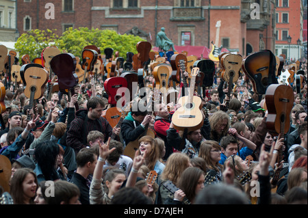 People hold guitars in the air as they attempt to break the Guinness World Record. Stock Photo