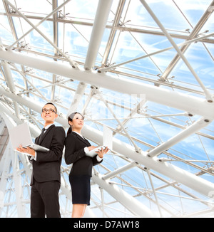young business man and woman holding laptop and stand in the modern office Stock Photo