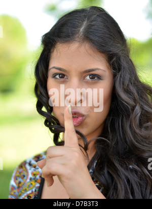 Beautiful brunette girl showing silence gesture Stock Photo